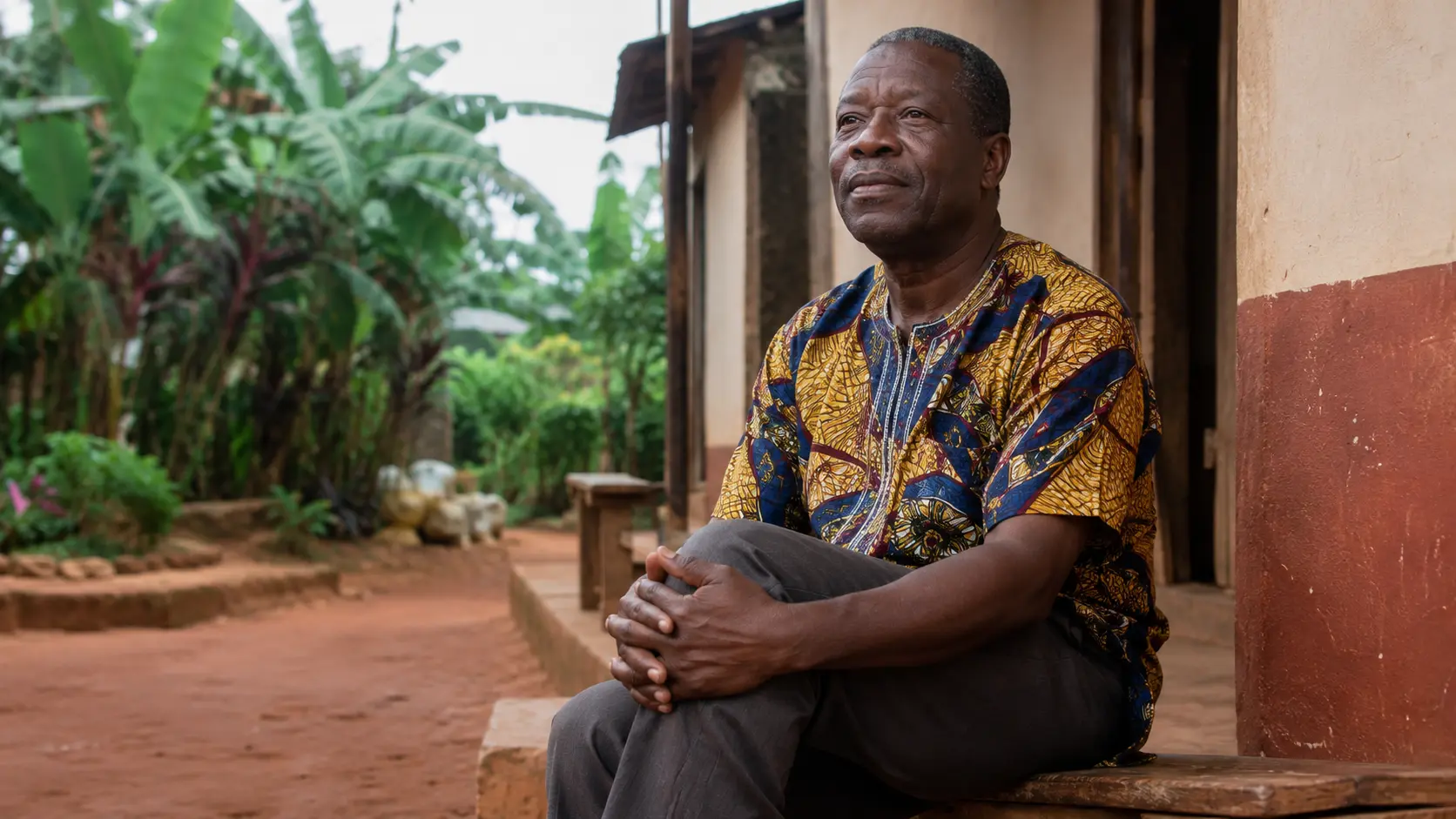 Homme camerounais assis, les mains posées sur le genou